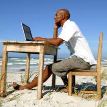 photo of Man working at his desk on the beach